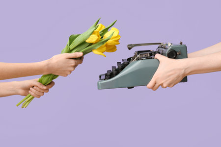 Female hands with retro typewriter and beautiful tulip flowers for International Women's Day on...