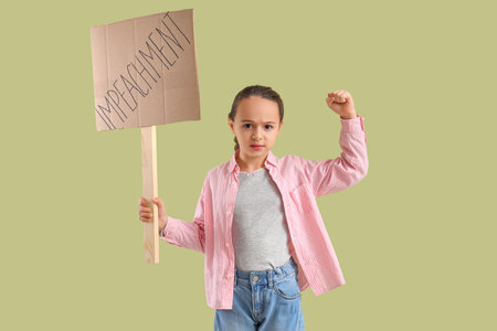 Protesting little girl holding placard with the word IMPEACHMENT on green backgroundの写真素材