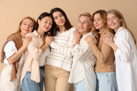 Portrait of beautiful hugging women on beige backgroundの写真素材