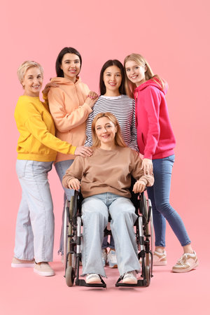 Group of people with woman in wheelchair on pink backgroundの写真素材