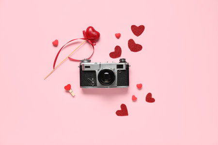Composition with vintage photo camera and decor for Valentine's Day celebration on color background