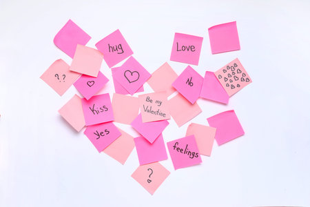 Heart made of pink sticky notes with messages on white background. Valentine's Day celebration