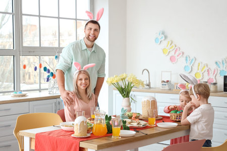 Happy family in bunny ears having Easter dinner at home