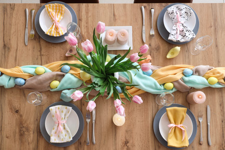 Beautiful Easter table setting with flowers, cutlery, napkins and painted eggs