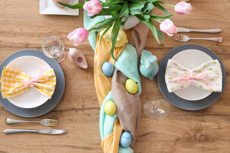 Beautiful Easter table setting with flowers, cutlery and painted eggs