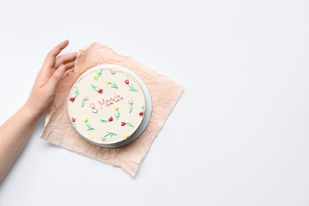 Female hand with sweet bento cake on white background. International Women's Dayの写真素材