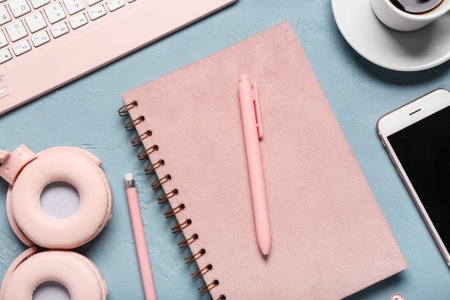 Notebook, pen, cup of coffee and headphones on blue background, closeupの写真素材