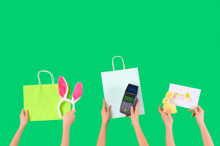 Women with payment terminal, Easter decor and bags on green background. Online shoppingの写真素材