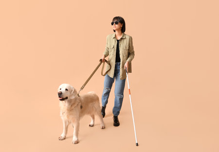 Blind woman with guide dog on beige backgroundの写真素材