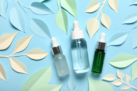 Facial cosmetic products composition with paper flowers on blue backgroundの写真素材