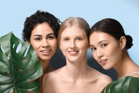 Beautiful young women with palm leaves on blue background, closeupの写真素材