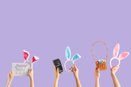 Women with payment terminal, bunny ears and Easter eggs on lilac background. Online shopping