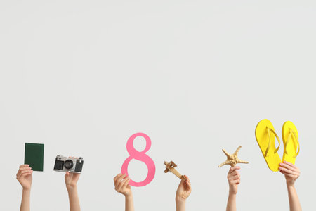 Female hands with paper figure 8, flip-flops, passport and photo camera on light background....