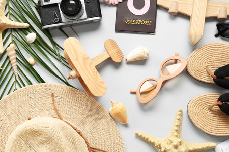 Composition with beach accessories, photo camera and palm leaf on light background. International...