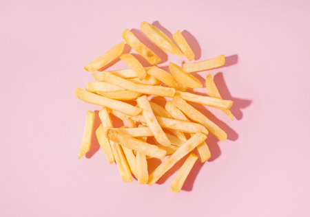 Tasty French fries on pink background