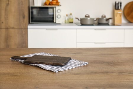 Wooden cutting board on table in modern kitchenの写真素材