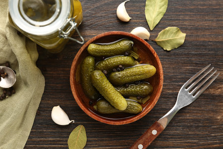 Bowl and jar with tasty canned cucumbers on wooden backgroundの写真素材
