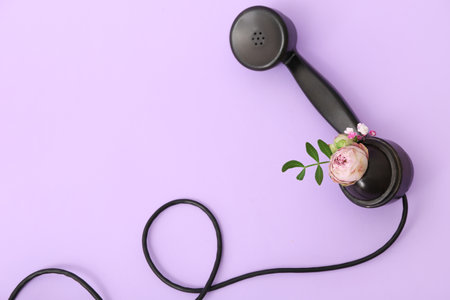 Retro telephone handset with flowers on lilac backgroundの写真素材