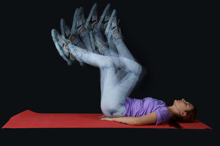 Young fitness trainer in motion on dark background