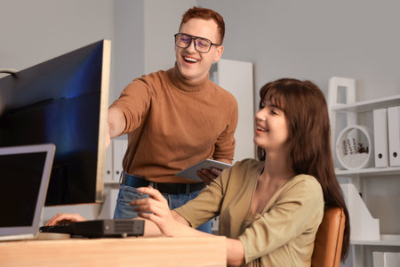 Young programmers working at office in eveningの写真素材