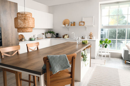 Clean island table with wooden chairs in interior of modern kitchenの写真素材