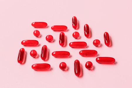 Many red pills on pink backgroundの写真素材