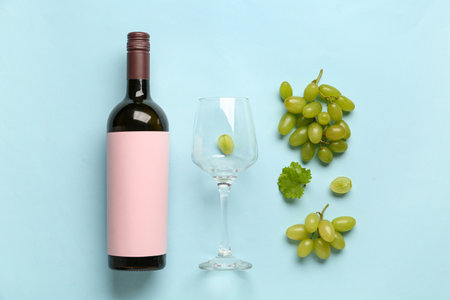 Bottle of red wine with blank label and white grapes on color background, top viewの写真素材