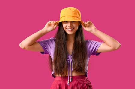 Stylish young woman in bucket hat on purple backgroundの写真素材