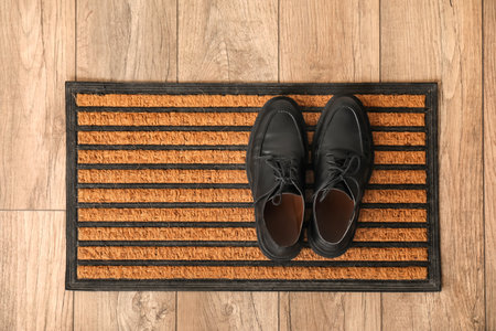 Doormat with male shoes on floor, top viewの写真素材