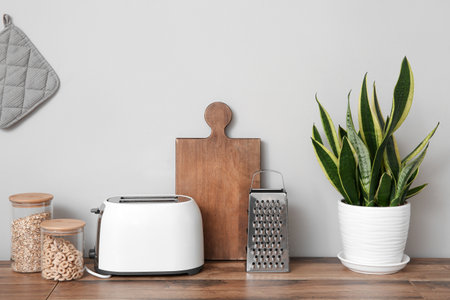 Wooden kitchen countertop with utensils, toaster and houseplantの写真素材