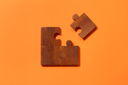 Wooden puzzle pieces on orange backgroundの写真素材