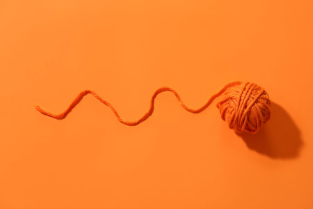 Ball of yarn on orange background