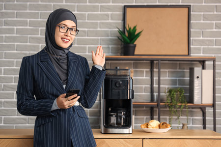 Muslim businesswoman with mobile phone in officeの写真素材