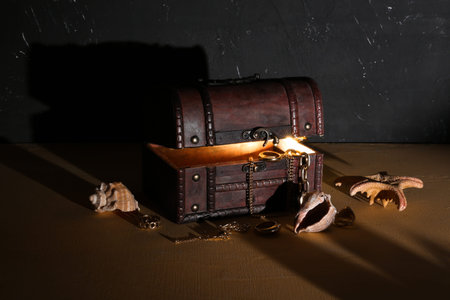 Old chest with treasures and seashells on dark backgroundの写真素材