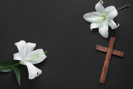 Frame made of beautiful lily flowers and cross on black backgroundの写真素材