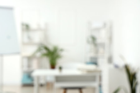 Blurred view of light office with workplace and shelf unitsの写真素材