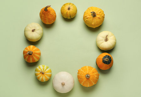Frame made of different fresh pumpkins on green backgroundの写真素材