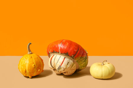 Different fresh pumpkins on orange backgroundの写真素材