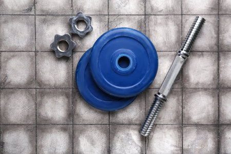 Barbell plates, clamps and grip on gray tile backgroundの写真素材