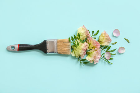 Composition with paint brush and beautiful flowers on color backgroundの写真素材