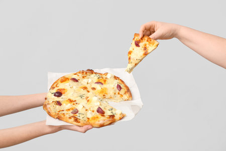 Female hands holding tasty pizza on white backgroundの写真素材