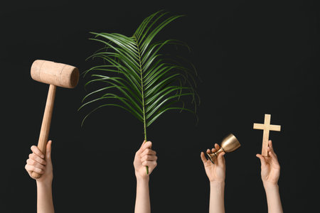 Female hands with wooden mallet, palm leaf, cup and cross on dark background. Good Friday conceptの写真素材