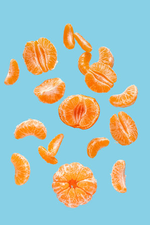 Flying sweet peeled mandarins on blue backgroundの写真素材