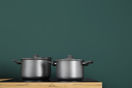 Wooden kitchen countertop with cooking pots on electric stoveの写真素材