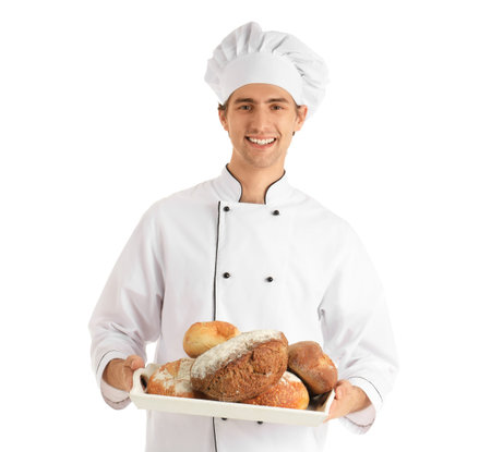 Handsome young chef holding tray with fresh bread on white background