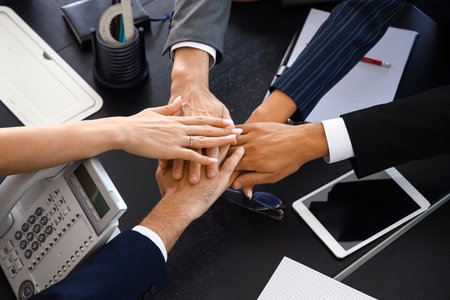 Group of business people putting hands together at table in conference hall, top viewの写真素材