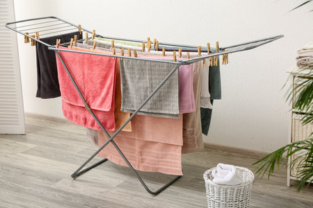 Clean towels hanging on dryer in laundry roomの写真素材