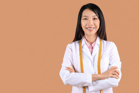 Female Asian nutritionist on beige backgroundの写真素材
