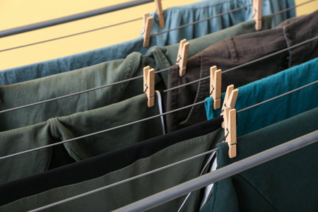 Clean green clothes hanging on dryer, closeupの写真素材