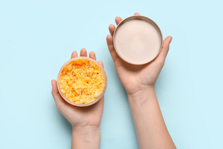 Female hands with natural jar of body scrub on color background, closeupの写真素材